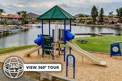 Diamond Point Park playground with a green-roofed tower and slides beside the lake.
