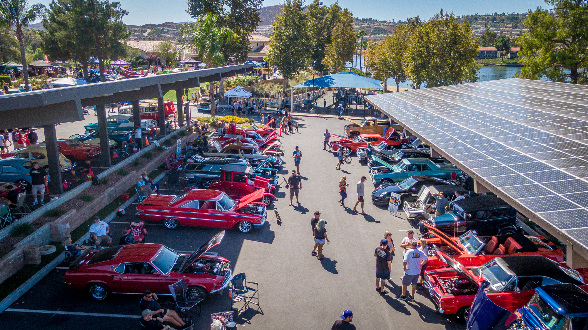 Rows of classic cars and attendees at the 2025 Canyon Lake Car Show, with the lake beyond.